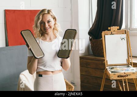 Eine Frau hält Bretter mit Yoganägeln in den Händen. Stockfoto