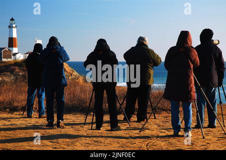 Eine Gruppe von Vogelbeobachtern versammelt sich am Montauk Point, in der Nähe des Leuchtturms an der östlichen Spitze von Long Island, an einem Wintertag, um die Tierwelt zu beobachten Stockfoto