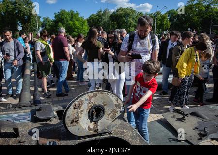 Kiew, Ukraine. 29.. Mai 2022. Während einer Ausstellung, in der russische Militärgeräte gezeigt werden, die während der russischen Invasion in der Ukraine im Zentrum von Kiew zerstört wurden, sehen sich die Menschen Fragmente eines zerstörten russischen Panzers an. Am 24. Februar 2022 drangen russische Truppen in die Ukraine ein und begannen einen Konflikt, der Zerstörung und eine humanitäre Krise provozierte. (Foto von Oleksii Chumachenko/SOPA Images/Sipa USA) Quelle: SIPA USA/Alamy Live News Stockfoto