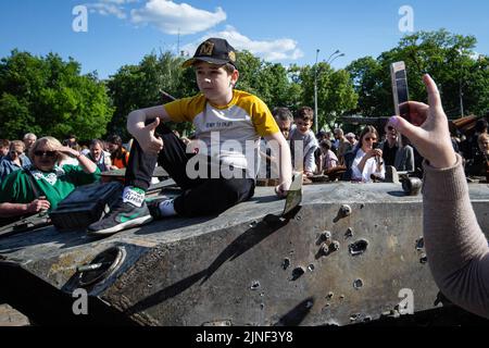 29. Mai 2022, Kiew, Ukraine: Ein Junge posiert für einen Fotografen, während er auf einem ausgebrannten russischen Panzerträger sitzt, während eine Ausstellung zeigt, in der russische Militärgeräte während der russischen Invasion der Ukraine in Zentral-Kiew zerstört wurden. Am 24. Februar 2022 drangen russische Truppen in die Ukraine ein und begannen einen Konflikt, der Zerstörung und eine humanitäre Krise provozierte. (Bild: © Oleksii Chumachenko/SOPA Images via ZUMA Press Wire) Stockfoto