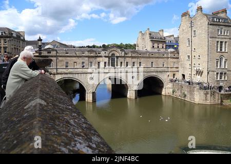 BATH, GROSSBRITANNIEN - 14. MAI 2014: Es handelt sich um die dreibögige Pulteney-Brücke über den Avon-Fluss, die im 18.. Jahrhundert erbaut wurde und auf beiden Seiten mit b Stockfoto
