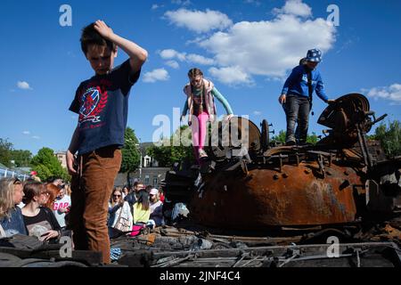 Kiew, Ukraine. 29.. Mai 2022. Kinder spielen auf einem zerstörten russischen Panzer während einer Ausstellung, in der russische militärische Hardware gezeigt wird, die während der russischen Invasion der Ukraine in Zentral-Kiew zerstört wurde. Am 24. Februar 2022 drangen russische Truppen in die Ukraine ein und begannen einen Konflikt, der Zerstörung und eine humanitäre Krise provozierte. (Bild: © Oleksii Chumachenko/SOPA Images via ZUMA Press Wire) Stockfoto