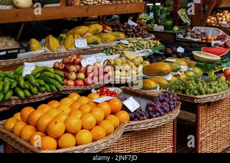 FUNCHAL, PORTUGAL - 24. AUGUST 2021: Dies ist ein Stall auf dem Bauernmarkt voller tropischer Früchte. Stockfoto