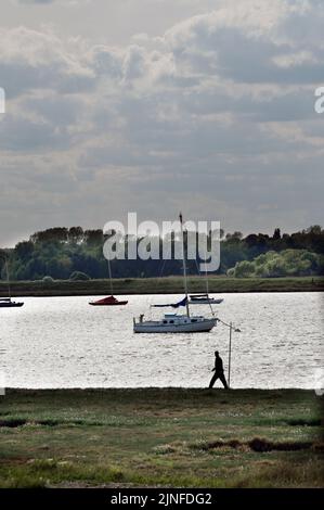 Ein Mann, der am Fluss alde entlang läuft, schlachtet am Kai aldeburgh suffolk england Stockfoto