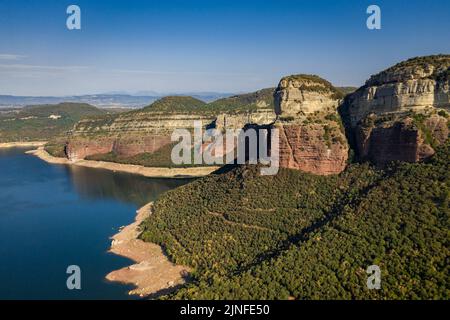 Luftaufnahme des Glockenturms von Sant Romà de Sau und des Sau-Stausees während der Sommertrockenheit von 2022 (Osona, Barcelona, Katalonien, Spanien) Stockfoto