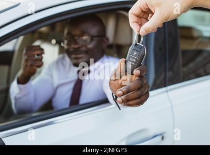 Das Konzept des Kaufs oder Mietens eines Autos. Nahaufnahme der Schlüsselübergabe. Mietauto. Kauf eines neuen Fahrzeugs Stockfoto