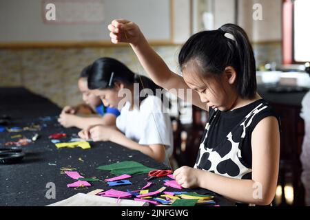 (220811) -- HEFEI, 11. August 2022 (Xinhua) -- Studenten lernen Stickereien in Hefei, ostchinesischer Provinz Anhui, 10. August 2022. Einige Schulen in Hefei bieten in diesem Sommer kostenlose Kindertagesstätten für Schüler an. Die Kindertagesstätten helfen nicht nur, die Sommerzeit der Schüler zu bereichern, sondern auch, den Druck auf berufstätige Eltern zu lockern, die sich sonst während der Ferien um ihre Kinder kümmern müssen. (Xinhua/Zhou Mu) Stockfoto