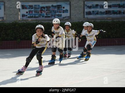 (220811) -- HEFEI, 11. August 2022 (Xinhua) -- Schüler lernen Rollschuhlaufen in Hefei, ostchinesischer Provinz Anhui, 10. August 2022. Einige Schulen in Hefei bieten in diesem Sommer kostenlose Kindertagesstätten für Schüler an. Die Kindertagesstätten helfen nicht nur, die Sommerzeit der Schüler zu bereichern, sondern auch, den Druck auf berufstätige Eltern zu lockern, die sich sonst während der Ferien um ihre Kinder kümmern müssen. (Xinhua/Zhou Mu) Stockfoto