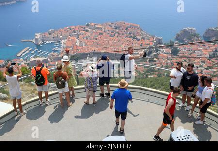 Zahlreiche Touristen kommen mit der Seilbahn auf den Srdj Hügel, wo sie am 11. August 2022 einen schönen Blick auf Dubrovnik, Kroatien, genießen. Stockfoto