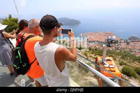 Zahlreiche Touristen kommen mit der Seilbahn auf den Srdj Hügel, wo sie am 11. August 2022 einen schönen Blick auf Dubrovnik, Kroatien, genießen. Stockfoto