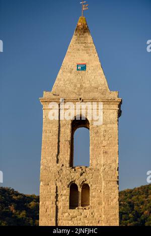 Sonnenaufgang am Glockenturm von Sant Romà de Sau und dem Stausee Sau während der Sommertrockenheit von 2022 (Osona, Barcelona, Katalonien, Spanien) Stockfoto