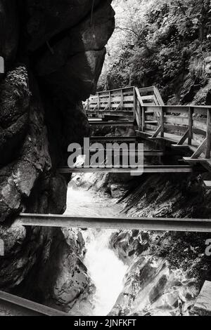 Eine Graustufenaufnahme einer Fußgängerbrücke über die Seisenbergklamm in Weissbach bei Lofer, Österreich Stockfoto