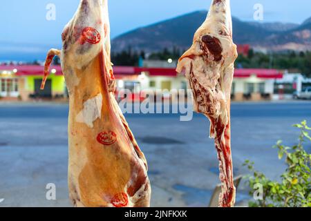 Frisches Fleisch hängt in einer Metzgerei Stockfoto