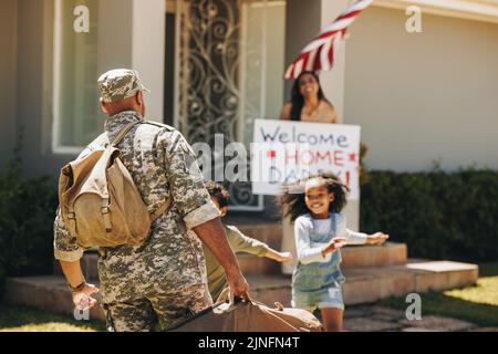 Wir heißen den Dardist aus der Armee willkommen. Der Vater des Militärs wurde von seiner Frau und seinen Kindern zu Hause herzlich willkommen geheißen. Amerikanischer Soldat kehrt afte zu seiner Familie zurück Stockfoto