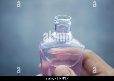 Halten Sie einen Behälter für Mundwasser mit der Hand Stockfoto