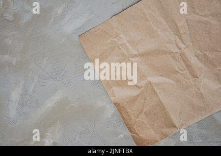 Zerknittertes braunes Papier und grauer Hintergrund, handwerkliche Papiertextur Stockfoto