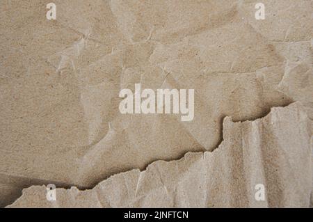 Zerknittertes braunes Papier mit abgerissenen Kanten, kunstvoller Papiertextur-Hintergrund Stockfoto