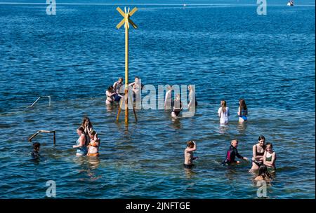 North Berwick, East Lothian, Schottland, Großbritannien, 11.. August 2022. UK Wetter: Kühl halten in der Hitze. Mit einer Temperatur von bis zu 27 Grad bietet die Küstenstadt Möglichkeiten zur Abkühlung. Kinder in Badeanzügen kühlen sich im Meer auf dem alten Pier ab, wenn die Flut steigt und sie im Sommer bei der Hitzewelle bedeckt Stockfoto