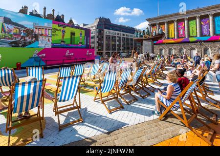 Menschenmassen beobachten die Commonwealth Games 2022 auf großen Leinwänden auf dem Festivalgelände am Victoria Square, Birmingham Stockfoto