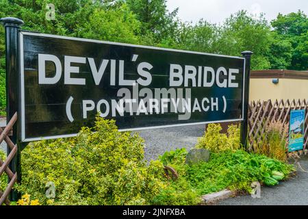 DEVIL'S BRIDGE, WALES - 06. JULI 2022: Devil's Bridge Schild auf dem Bahnsteig am Bahnhof Stockfoto