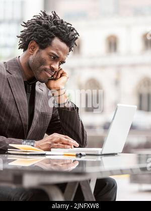 Arbeiten Im Freien. Ein junger Londoner Business-Profi, der gerne außerhalb des Büros arbeitet. Aus einer Serie von verwandten Bildern mit demselben Modell. Stockfoto
