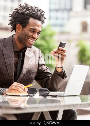 Arbeiten Im Freien. Ein junger Londoner Business-Profi, der gerne außerhalb des Büros arbeitet. Aus einer Serie von verwandten Bildern mit demselben Modell. Stockfoto