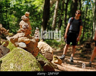 Ilsenburg, Deutschland. 11. August 2022. Im Ilse-Tal liegen gestapelte Steine, auch Cairns genannt. Die Tatsache, dass Menschen Steine auftürmen, hat oft kulturellen oder religiösen Hintergrund. Vor allem aber sollen die cairns guten und bösen Geistern entgegenwirken.wieder einmal sind die Temperaturwerte stark gestiegen. Bis zum Wochenende ändert sich das Wetter kaum. Quelle: Matthias Bein/dpa/Alamy Live News Stockfoto