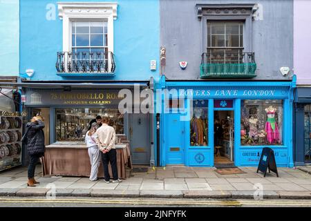 London, Großbritannien - 12. März 2022: Touristen stöbern in den farbenfrohen Geschäften der Portobello Road, London. Dieser Bezirk in Notting Hill ist berühmt für zahlreiche pa Stockfoto