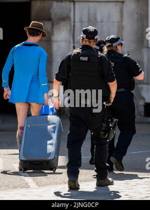 London, Großbritannien. 11. August 2022. Ein Mann ohne Hose, das wie ein Star Trek-Kleid aussieht und marginal enthüllende Unterhosen wird zur Befragung durch die bewaffnete Polizei bei Horse Guards weggenommen - die zweite kurze Hitzewelle des Jahres macht das Leben im Zentrum Londons ungemütlich. Kredit: Guy Bell/Alamy Live Nachrichten Stockfoto