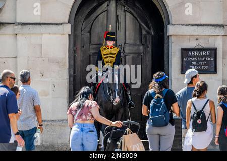 London, Großbritannien. 11. August 2022. Die Königstruppe der Königlichen Pferdeartillerie nimmt die Wache der Pferdegarde auf, die wie üblich von einer Touristenschar beobachtet wird - Reiter und Pferde bleiben trotz der Hitze ruhig. Die zweite kurze Hitzewelle des Jahres macht das Leben in Central London unangenehm. Kredit: Guy Bell/Alamy Live Nachrichten Stockfoto