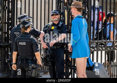 London, Großbritannien. 11. August 2022. Ein Mann ohne Hose, das wie ein Star Trek-Kleid aussieht und marginal enthüllende Unterhosen wird zur Befragung durch die bewaffnete Polizei bei Horse Guards weggenommen - die zweite kurze Hitzewelle des Jahres macht das Leben im Zentrum Londons ungemütlich. Kredit: Guy Bell/Alamy Live Nachrichten Stockfoto