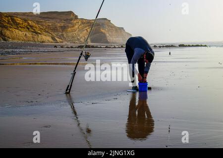 Laayoune, Marokko - 30. Juli 2022: Ein Fischer und seine Fischerstange Stockfoto
