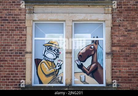 11. August 2022, Sachsen, Stollberg: Graffiti schmückt die Fenster eines Gebäudes auf dem Gelände des Alten Schlachthof in Stollberg. Das Industriegebäude wird heute als Veranstaltungsort für Konzerte, Workshops und Projekte genutzt. Die Stadt, die rund 11.500 Einwohner hat und an der Autobahn 72 liegt, kann auf eine Reihe von Beispielen verweisen, wie Millionen von Bundes- und Landesmitteln genutzt wurden, um etwas Neues zu schaffen oder alte Gebäude zu renovieren, die jetzt neu genutzt werden. Seit Anfang des Jahres 1990s flossen aus Bund und Ländern rund 6,2 Milliarden Euro in die sächsischen Städte Stockfoto