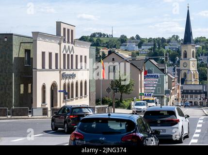 11. August 2022, Sachsen, Stollberg: Autos fahren über eine Kreuzung vor dem Bürgergarten (l) im Zentrum von Stollberg. Das teilweise neu erbaute Gebäude mit seinem historischen Saal im neoklassizistischen Stil wird für Veranstaltungen genutzt. Die Stadt, die rund 11.500 Einwohner hat und an der Autobahn 72 liegt, kann auf eine Reihe von Beispielen verweisen, wie Millionen von Bundes- und Landesmitteln genutzt wurden, um neue Dinge zu schaffen oder alte Gebäude zu renovieren und neu zu nutzen. Seit Anfang des Jahres 1990s wurden von der rund 6,2 Milliarden Euro in die Stadtumgestaltung der sächsischen Städte investiert Stockfoto