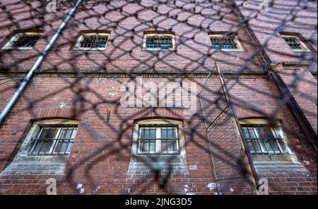 11. August 2022, Sachsen, Stollberg: Die Fenster des ehemaligen Frauengefängnisses Schloss Hoheneck sind versperrt. Hoheneck war einst das größte Frauengefängnis der DDR. 2023 soll hier ein Denkmal für das ehemalige Frauengefängnis eröffnet werden. Die Kosten für die aktuellen Pläne werden auf 27 Millionen Euro geschätzt, davon werden fast 19 Millionen Euro aus der Stadtentwicklungsförderung kommen. Die Stadt Stollberg, die rund 11.500 Einwohner hat und an der Autobahn 72 liegt, hat einige Beispiele dafür, wie Millionen Euro an Bund und Ländern für den Neubau oder die Renovierung von Altbauten verwendet wurden Stockfoto