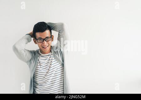 Porträt eines glücklichen jungen Mannes in einer Brille, der die Kamera anschaut Stockfoto