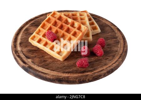 Hausgemachte Waffeln mit Beeren auf Holzbrett isoliert. Belgische Waffel mit Fruchthimbeere auf weißem Hintergrund Stockfoto