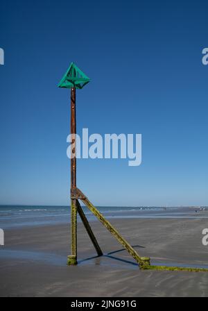 Ein groyner Marker-Pol bei Ebbe am East Wittering Beach, West Sussex, Großbritannien. Stockfoto