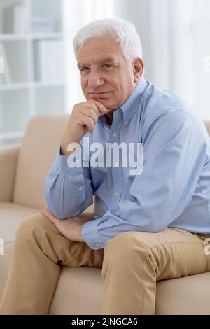 Porträt eines nachdenklichen älteren Mannes, der auf dem Sofa ruht Stockfoto
