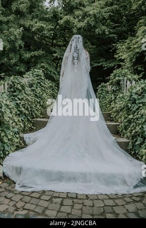 Braut im Park ist ein schönes langes Hochzeitskleid Umgedreht Stockfoto