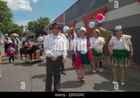 Marschiere in traditioneller Kleidung und mit hölzernen Tierstatuen.bei der ecuadorianischen Parade NYC 2022 in Queens, New York. Stockfoto