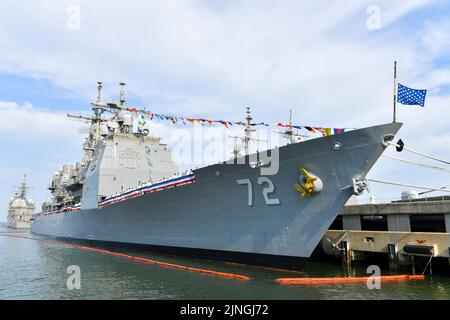 Matrosen der US-Marine und ehemalige Schiffsgefährten fahren auf den Schienen, bevor der geführte Raketenkreuzer USS Vella Gulf der Ticonderoga-Klasse auf der Naval Station Norfolk am 4. August 2022 in Norfork, Virginia, stillgelegt wird. Der Vella Golf wurde am 18. September 1993 in Betrieb genommen und ist der erste von fünf Kreuzern, die in diesem Jahr stillgelegt werden sollen. Stockfoto