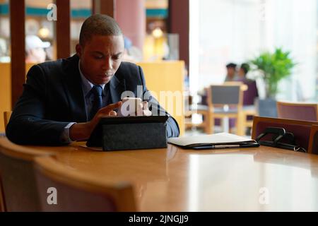 Serious afroamerikanischen Geschäftsmann Lesung Nachricht auf dem Smartphone Stockfoto