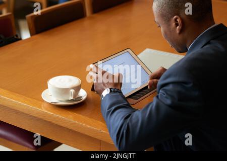 Geschäftsmann überprüft Informationen auf seinem Tablet-Computer Stockfoto