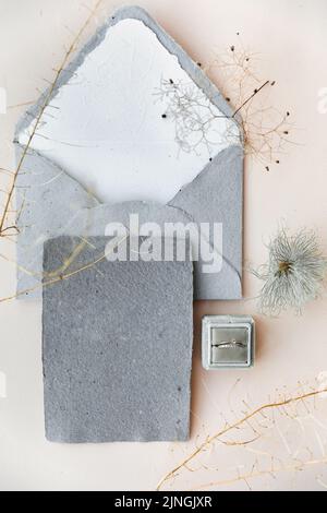 Eheringe in einer Schachtel und Vintage-Einladungen auf dem Tisch. Stockfoto