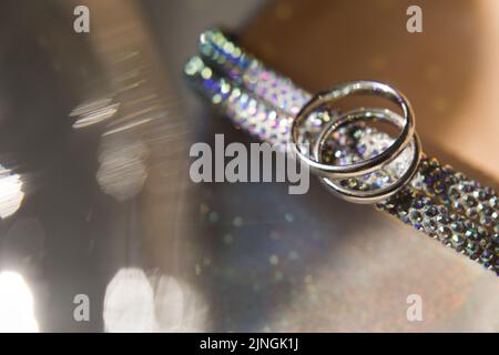 Zwei goldene Ringe liegen auf Hochzeitsschuhen. Stockfoto