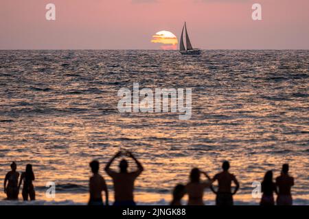 Tel Aviv, Israel. 10. August 2022. Strandbesucher genießen den Sonnenuntergang in Tel Aviv. Tel Aviv, das sich an der Mittelmeerküste befindet, ist Israels kulturelles Zentrum und ein wichtiges Reiseziel, das Touristen aus der ganzen Welt anzieht. (Bild: © Ronen Tivony/SOPA Images via ZUMA Press Wire) Stockfoto