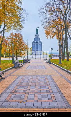 Fußgängerzone vor dem Prinz-Wolodymyr-Denkmal im Park des Wolodymyr-Hügels mit gelben Herbstbäumen, Kiew, Ukraine Stockfoto