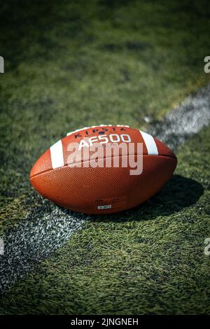 Eine vertikale Nahaufnahme eines amerikanischen Kipsta AF500-Fußballballs auf einem synthetischen Feld Stockfoto