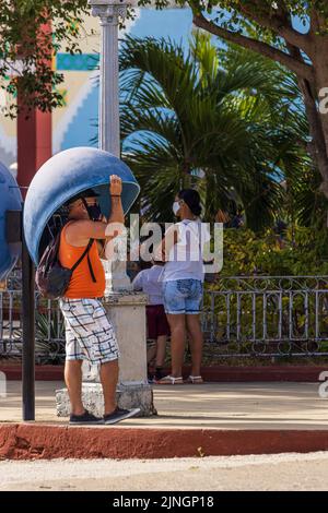 TRINIDAD, KUBA - JANUAR 6 2021: Mann, der am Telefon an einer Telefonzelle in Trinidad, Kuba, telefoniert Stockfoto